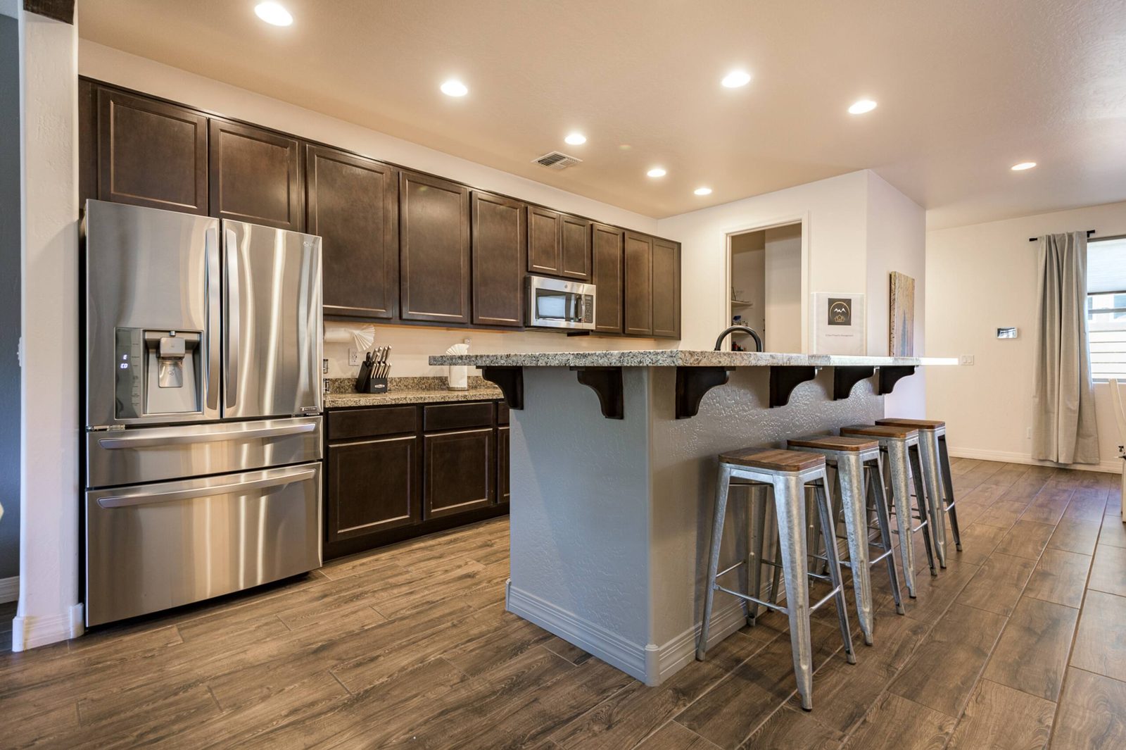 Kitchen with island, stools, and stainless appliances