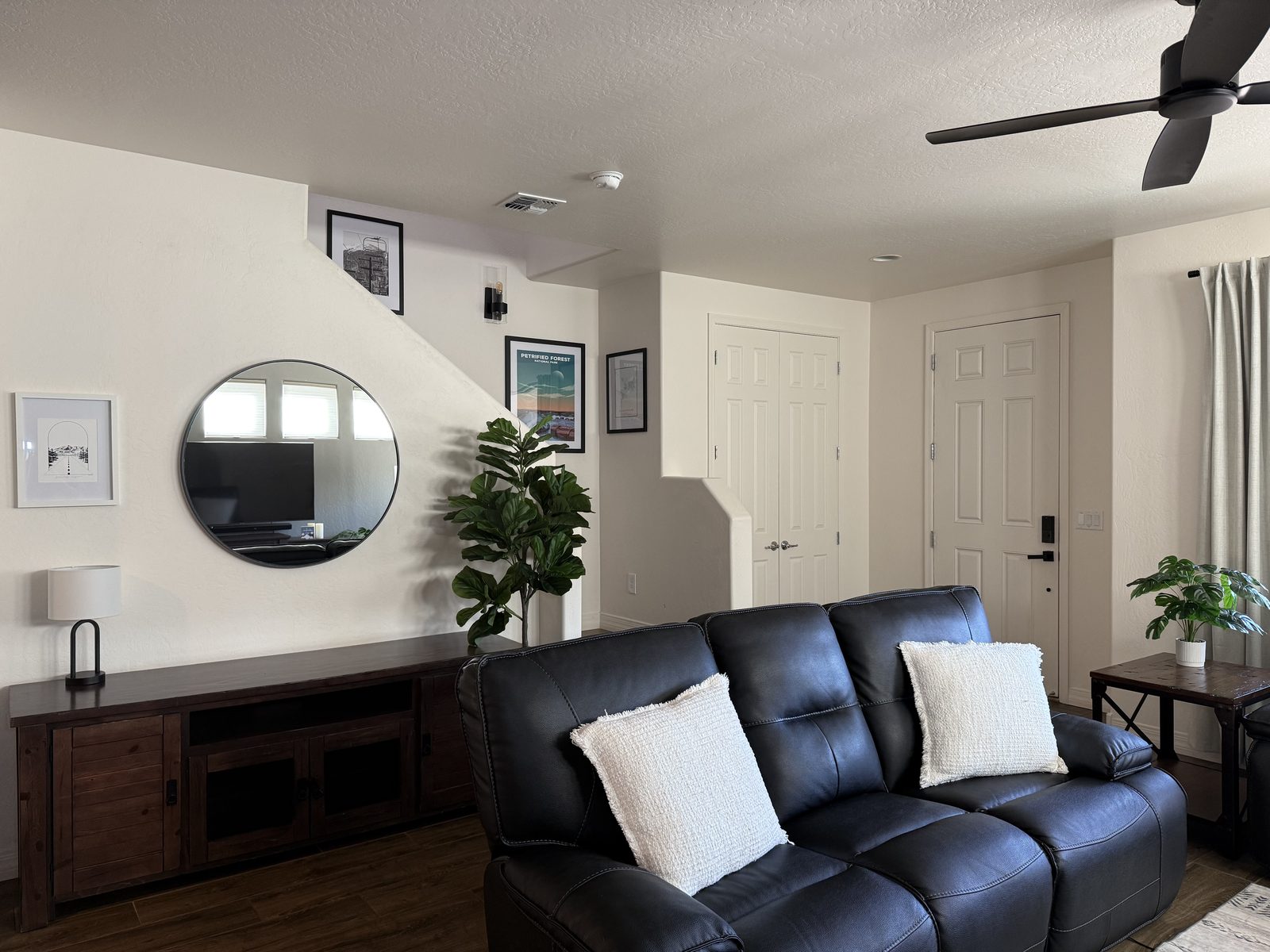 Living room with leather sofa and round mirror